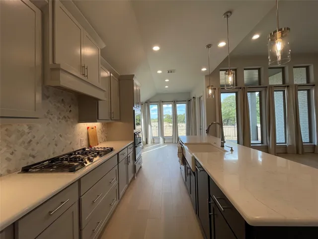 a large kitchen with kitchen island a sink a center island stainless steel appliances and cabinets