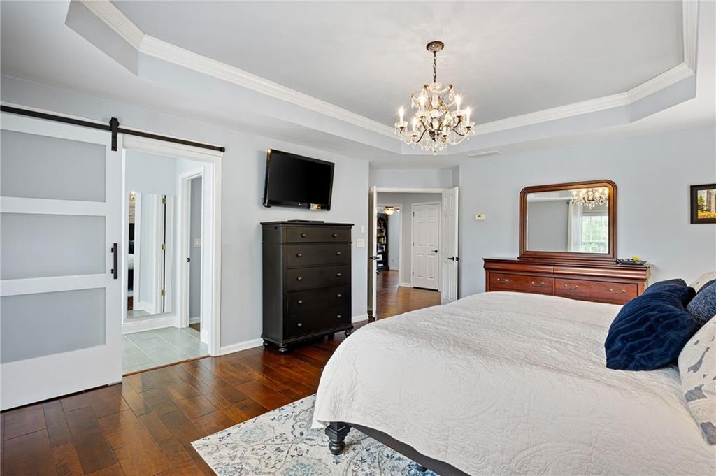 204 Golden Bell Way Canton, GA 30115 - Photo 29 of 81 a spacious bedroom with a bed and a flat screen tv