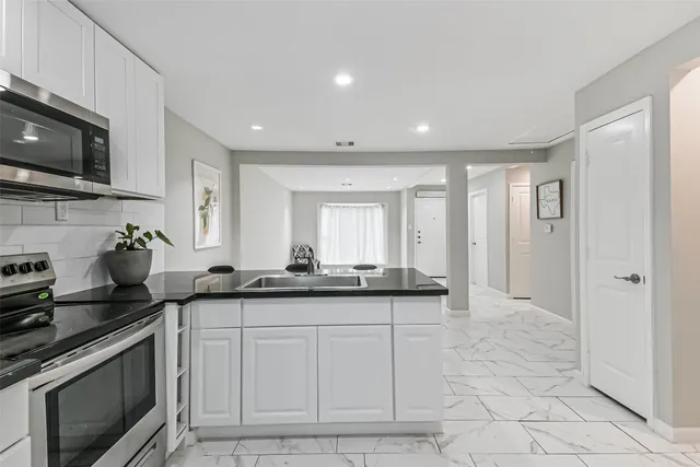 a kitchen with granite countertop a sink and a stove top oven a granite countertops