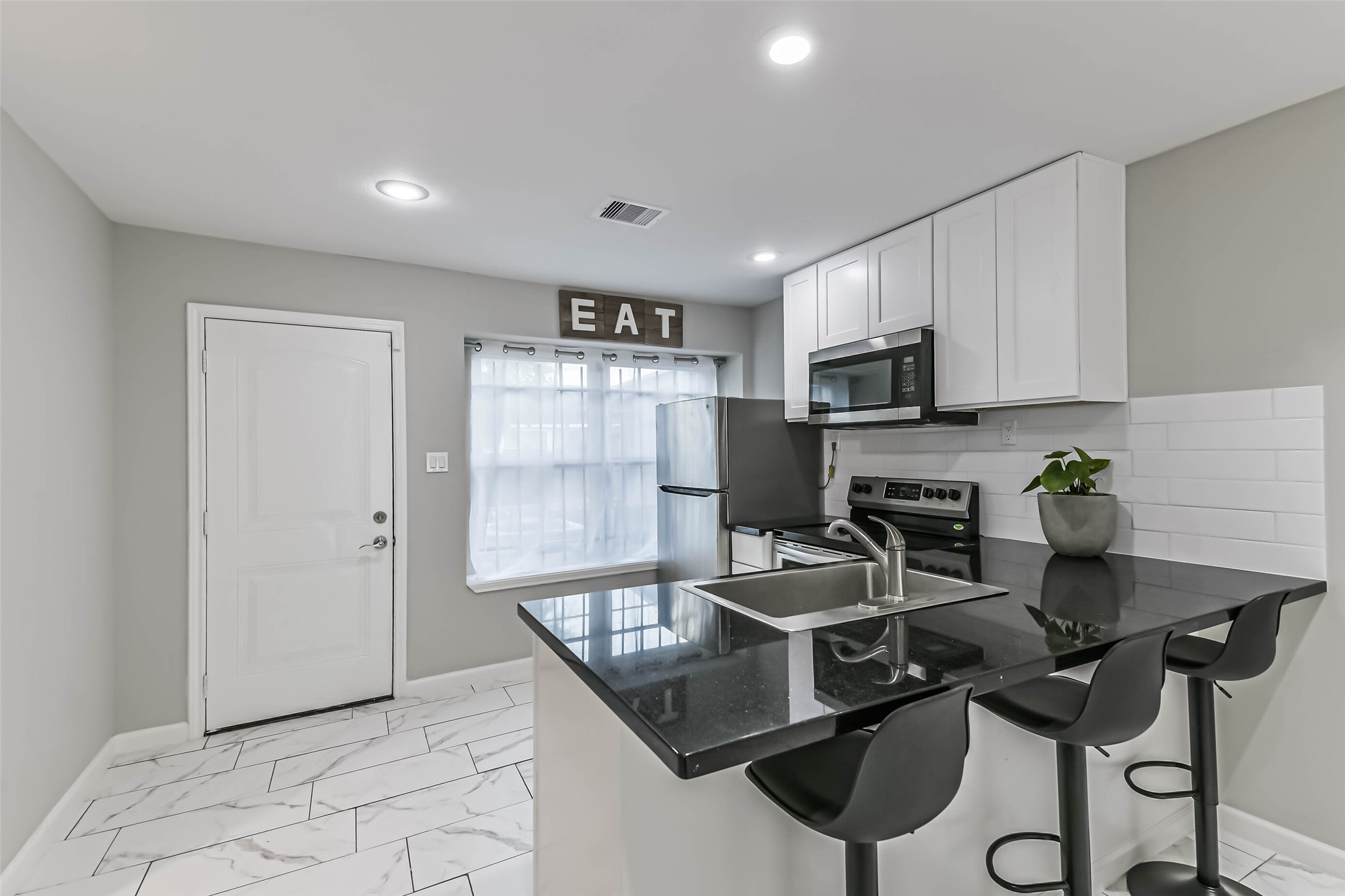 6853 Chasewood Drive Houston, TX 77489 - Photo 9 of 24 a kitchen with a table chairs refrigerator and microwave
