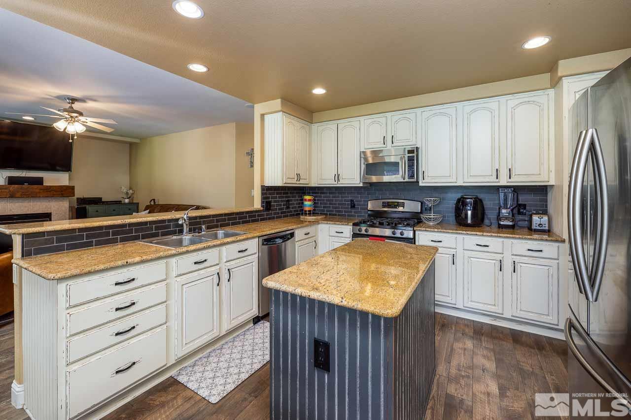 10015 Kentfield Place Reno, NV 89521 - Photo 8 of 28 a kitchen with stainless steel appliances granite countertop a stove sink and cabinets