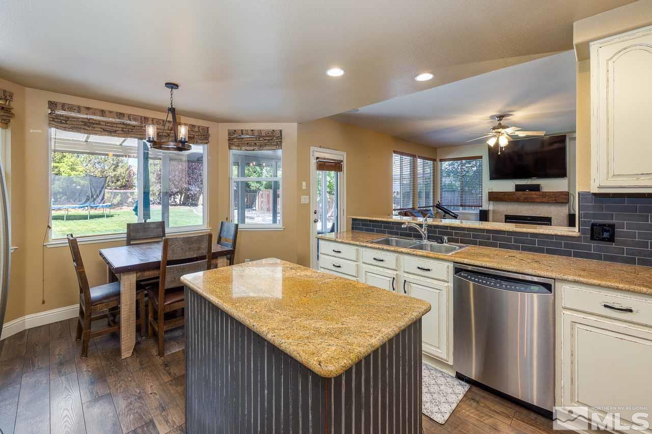 10015 Kentfield Place Reno, NV 89521 - Photo 9 of 28 a kitchen with kitchen island granite countertop a sink and microwave