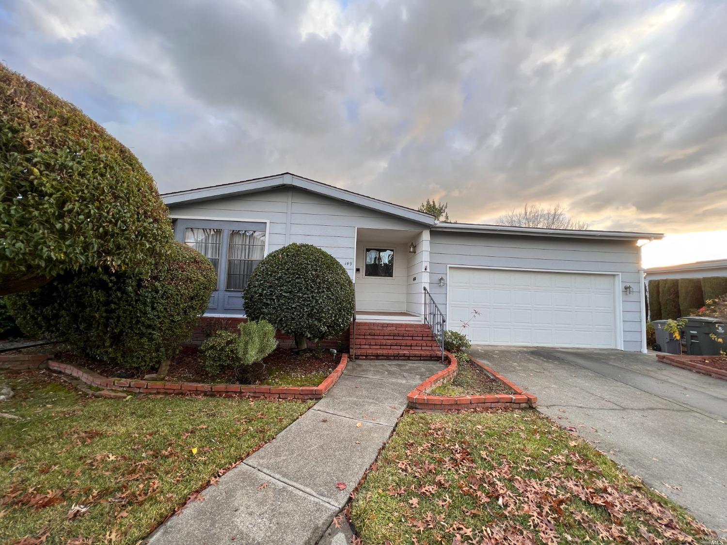 a backyard of a house with potted plants and a tree