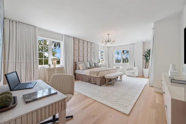 a spacious bedroom with a bed a table and chair