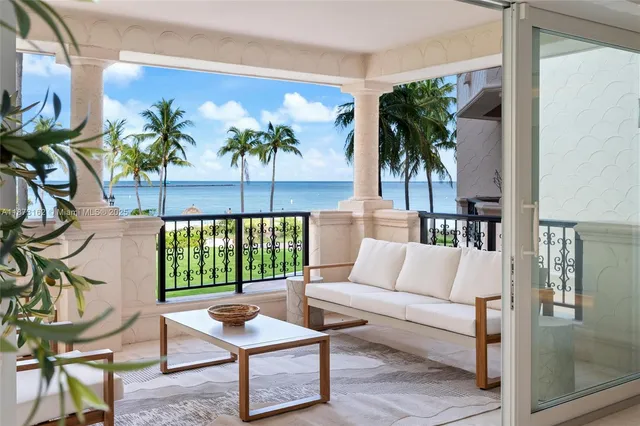 a living room with patio furniture and a potted plant