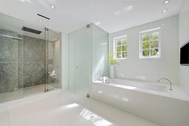 a white bed sitting in a bedroom next to a window