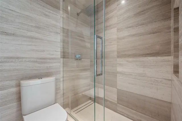 a bedroom with a bed and a flat tv screen on wall