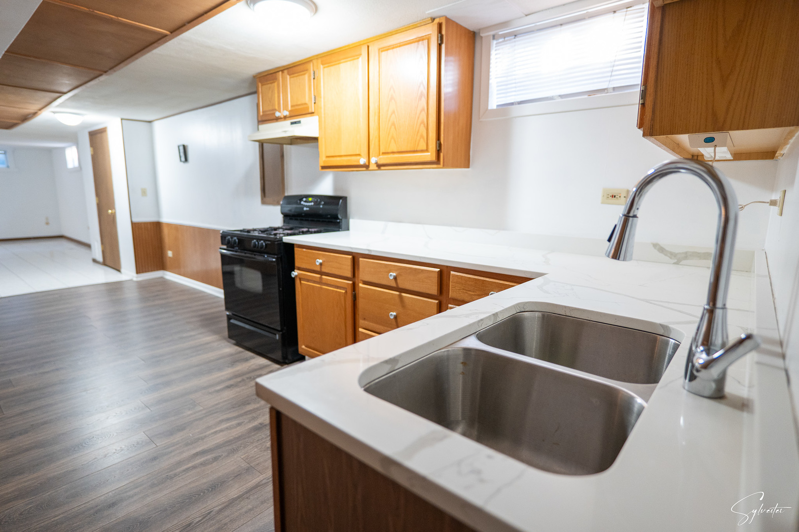 904 Chippewa Drive Elgin, IL 60120 - Photo 20 of 35 a kitchen with wooden cabinets a sink and a stove with wooden floor