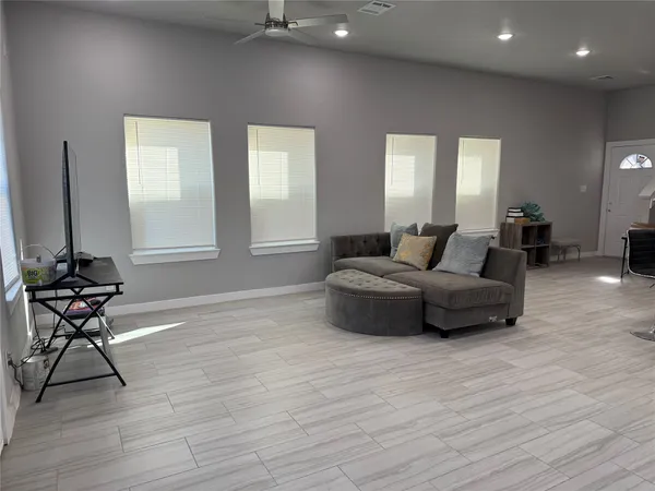 a living room with furniture and a wooden floor