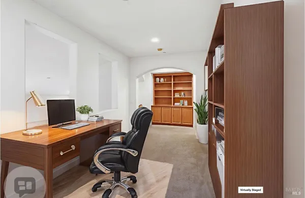 a view of a workspace with furniture and a window