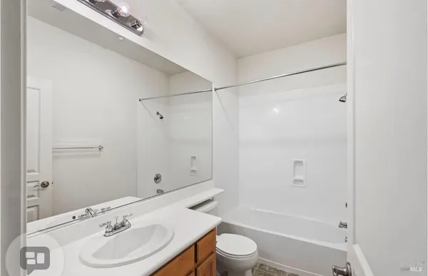 a bathroom with a bathtub shower sink vanity and toilet