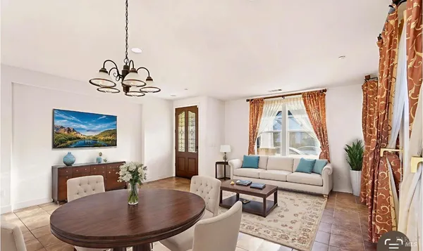 a living room with furniture a dining table and a window