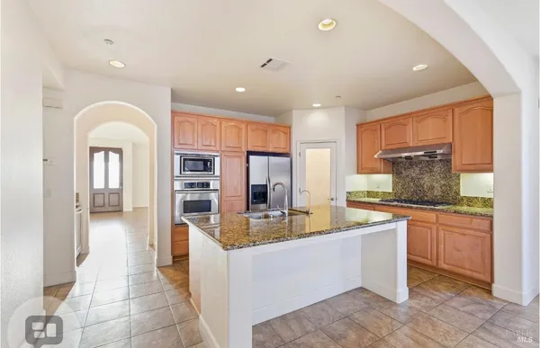 a large kitchen with stainless steel appliances granite countertop a large counter top and a stove