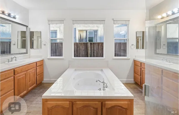 a bathroom with a sink mirror vanity and bathtub