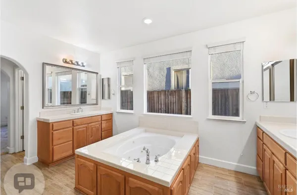 a bathroom with a tub sink and mirror