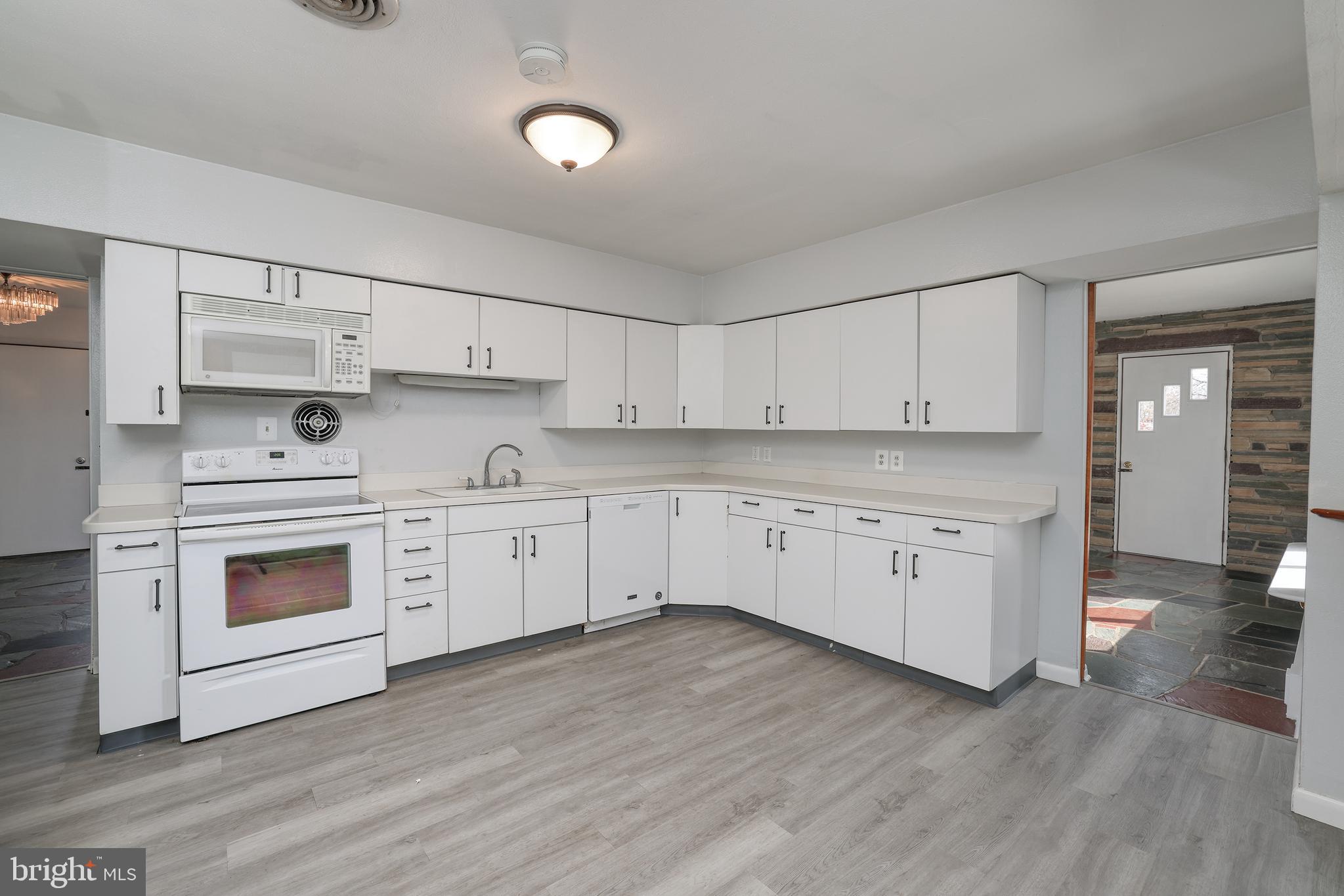 2627 Pennington Road Pennington, NJ 08534 - Photo 11 of 31 a kitchen with stainless steel appliances white cabinets and wooden floors