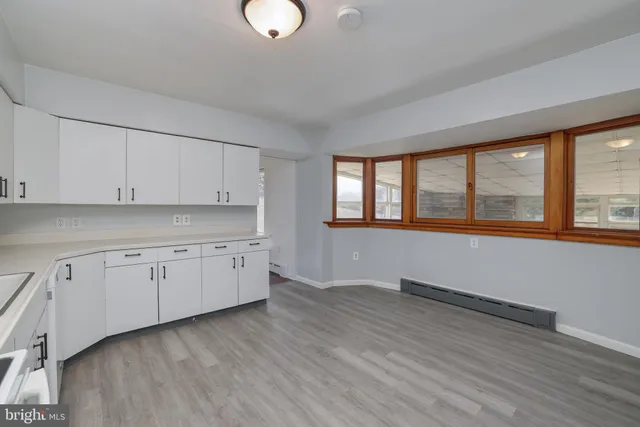 a kitchen with granite countertop white cabinets and wooden floor