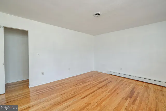 a view of empty room with wooden floor