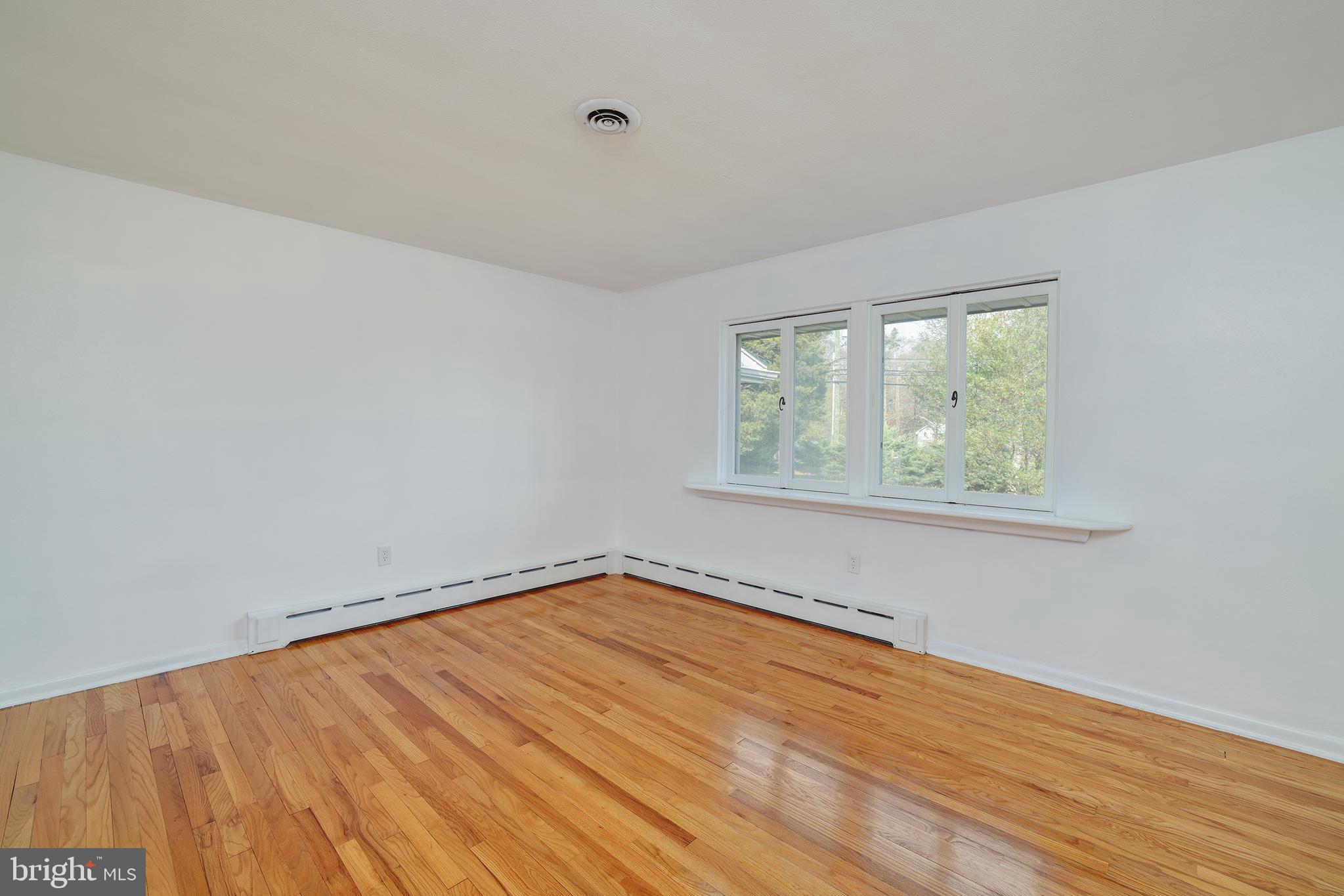 2627 Pennington Road Pennington, NJ 08534 - Photo 22 of 31 an empty room with wooden floor and windows