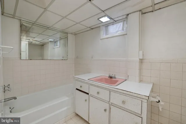 a bathroom with a bathtub sink vanity and mirror