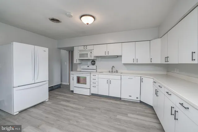 a kitchen with granite countertop white cabinets and white appliances