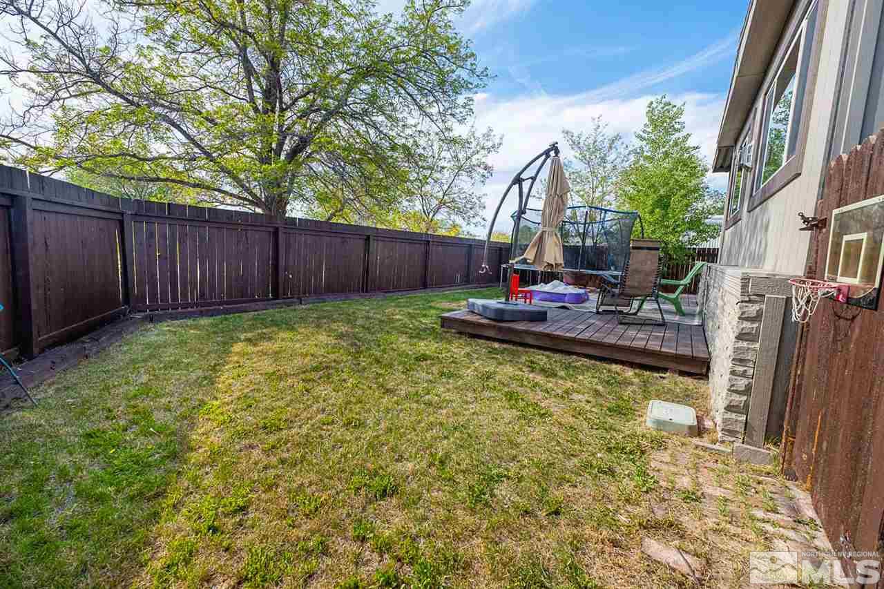 200 Gemini Circle Reno, NV 89521 - Photo 27 of 31 a view of a backyard with plants and large trees with wooden fence