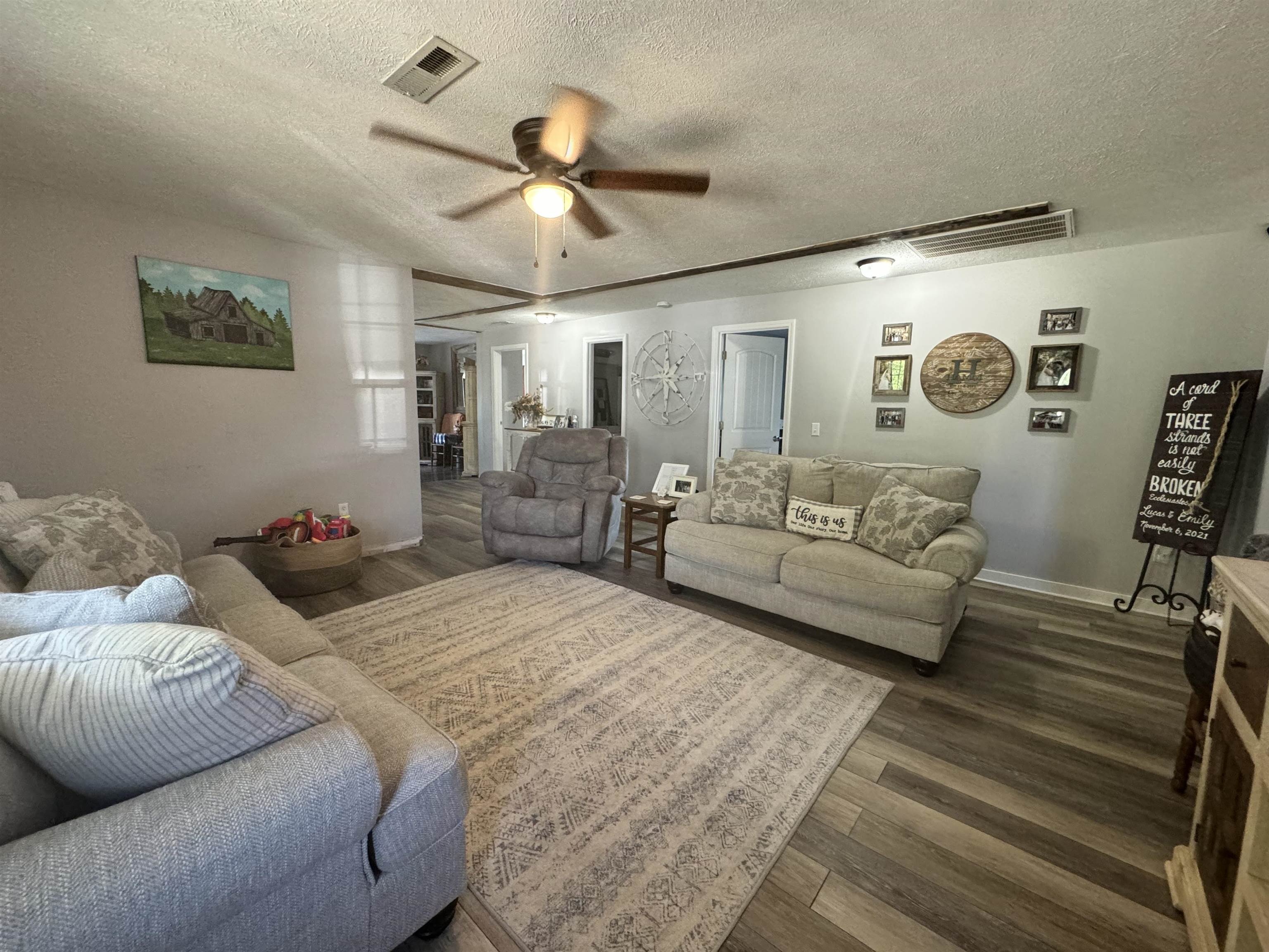 780 Ammons Road Selmer, TN 38375 - Photo 2 of 21 Living room featuring ceiling fan, a textured ceiling, and dark hardwood / wood-style flooring