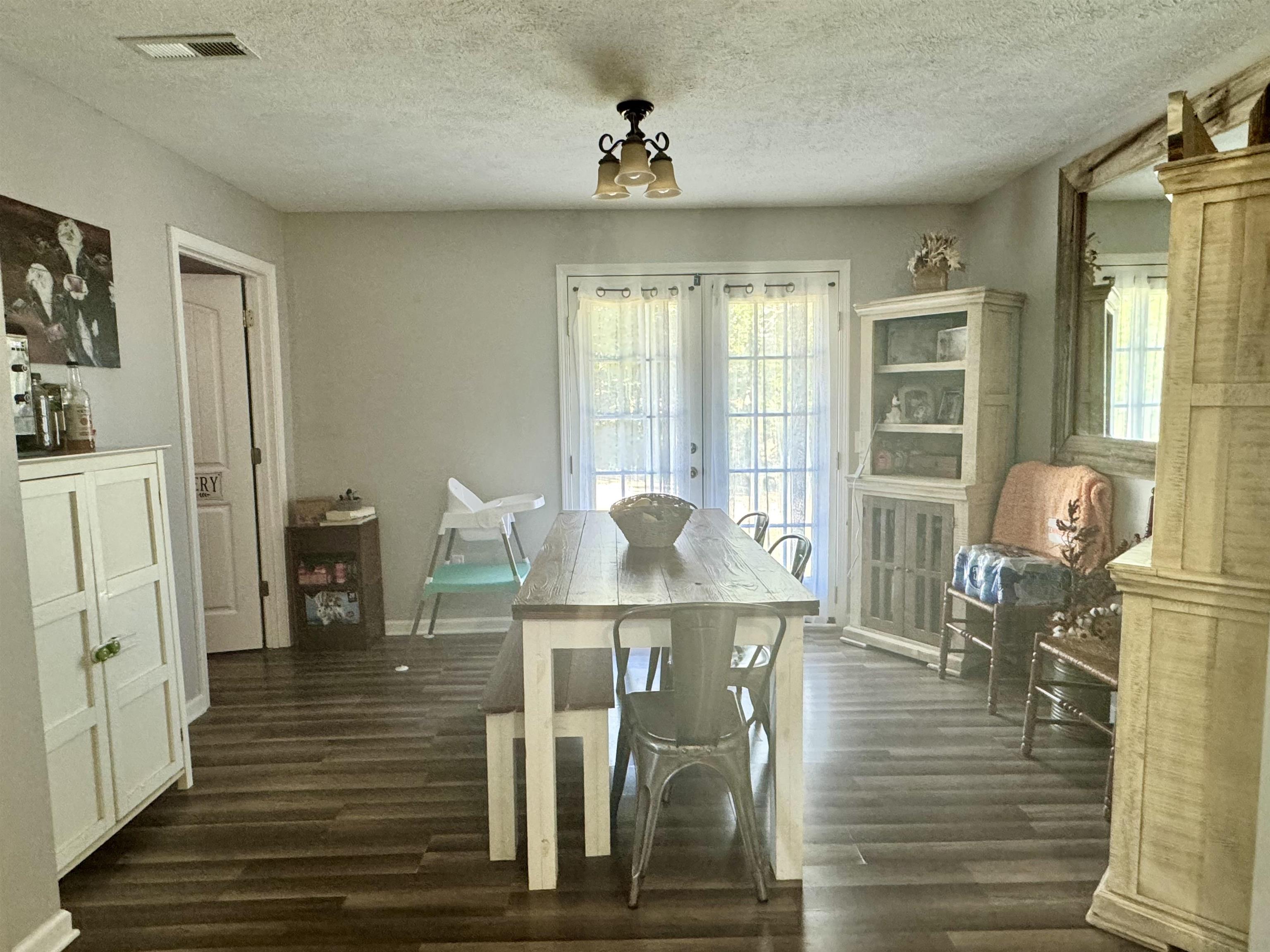 780 Ammons Road Selmer, TN 38375 - Photo 7 of 21 Dining area featuring dark wood-type flooring, french doors, and a textured ceiling