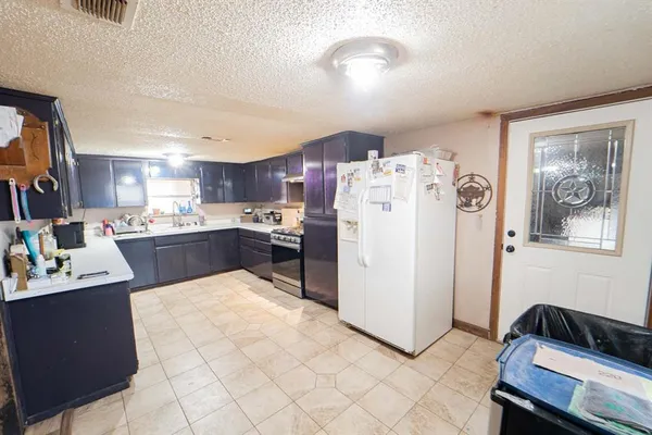 a kitchen with refrigerator and cabinets