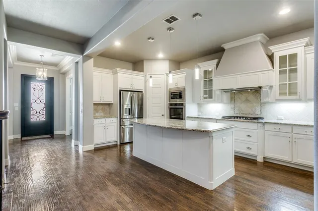 a large kitchen with stainless steel appliances lots of counter space and a sink