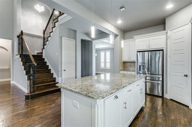 a kitchen with stainless steel appliances granite countertop a refrigerator and a sink