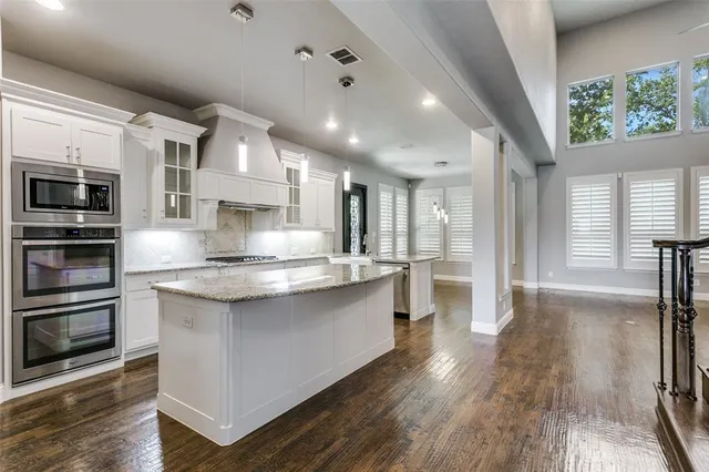 a large kitchen with kitchen island a large counter space a sink appliances and cabinets