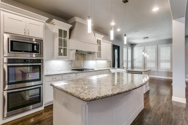 a kitchen with granite countertop a sink and stainless steel appliances