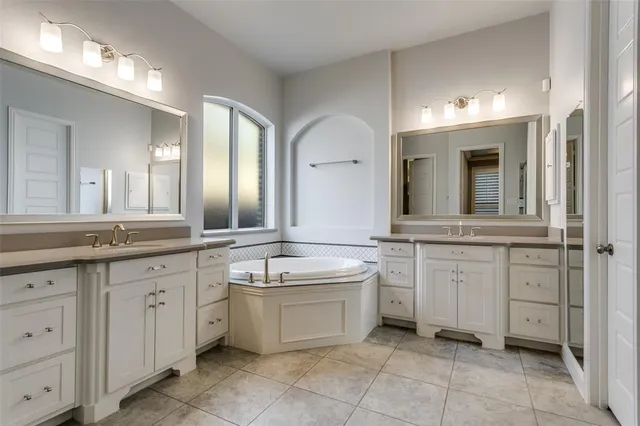a spacious bathroom with a granite countertop sink mirror and bathtub