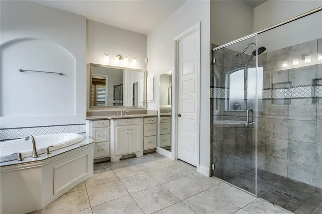 a bathroom with a double vanity sink mirror and shower