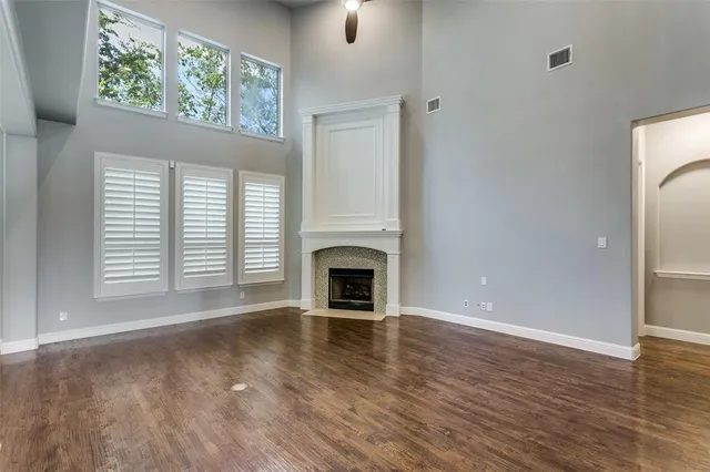 a view of a livingroom with a fireplace wooden floor and windows
