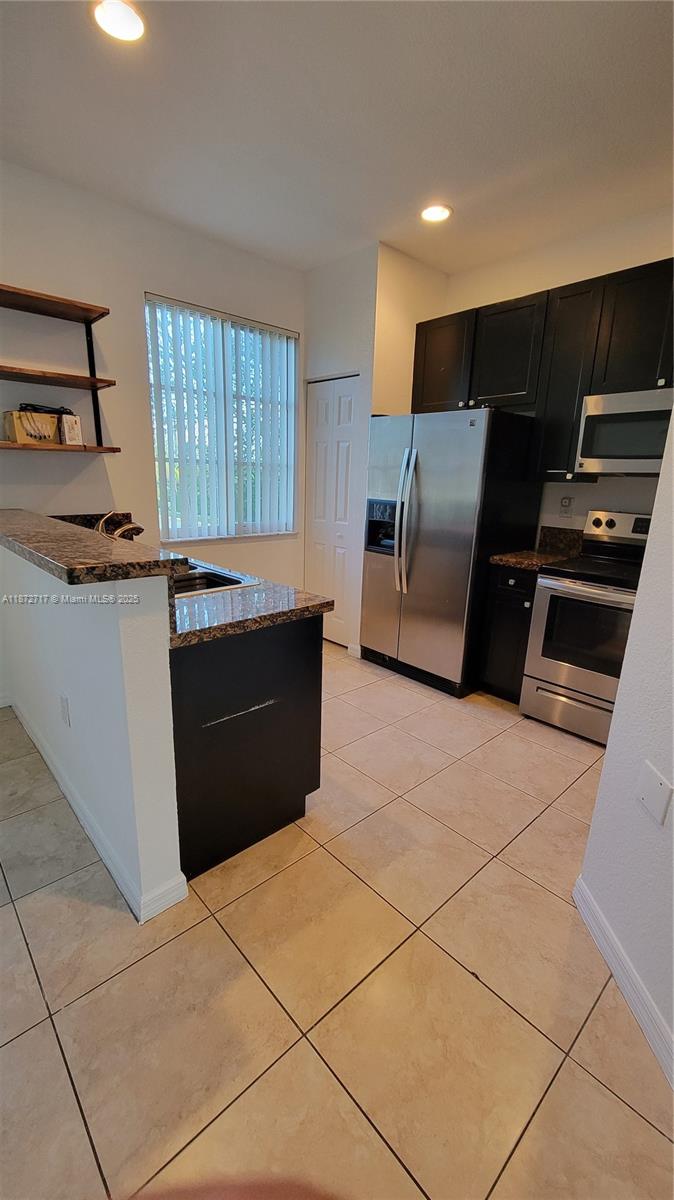 12600 Southwest 50th Court, Unit 437 Miramar, FL 33027 - Photo 8 of 28 a kitchen with stainless steel appliances a sink a stove a refrigerator a counter top space and cabinets