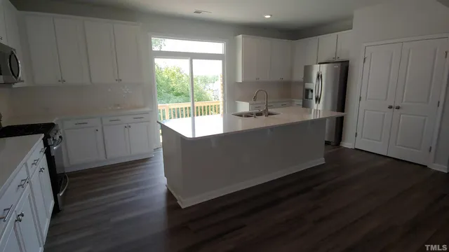 a view of a kitchen with wooden floor and electronic appliances