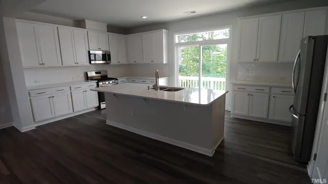 a kitchen with wooden cabinets a stove a sink and a window