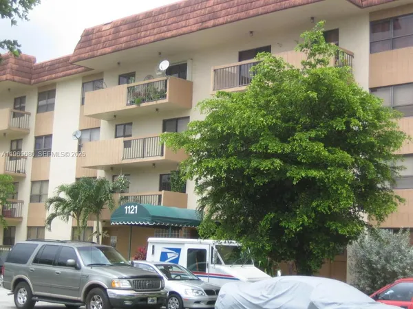 a front view of a building with trees