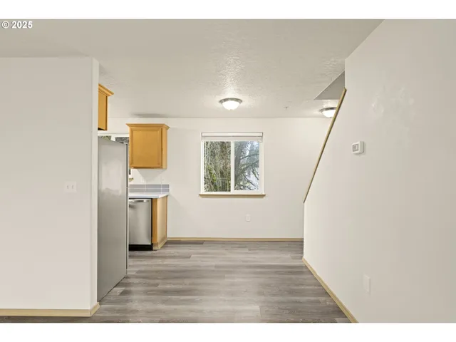 a view of empty room with wooden floor and window