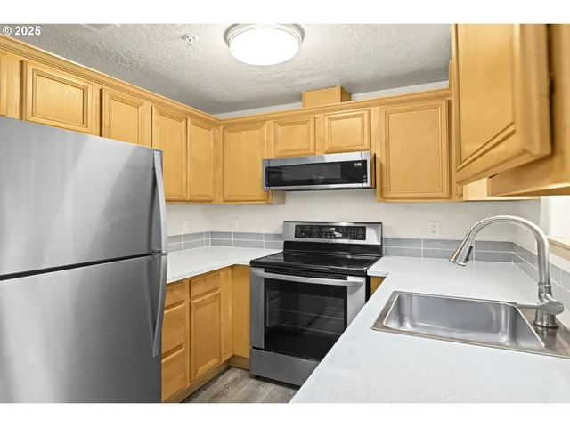 a kitchen with a refrigerator a sink and a stove