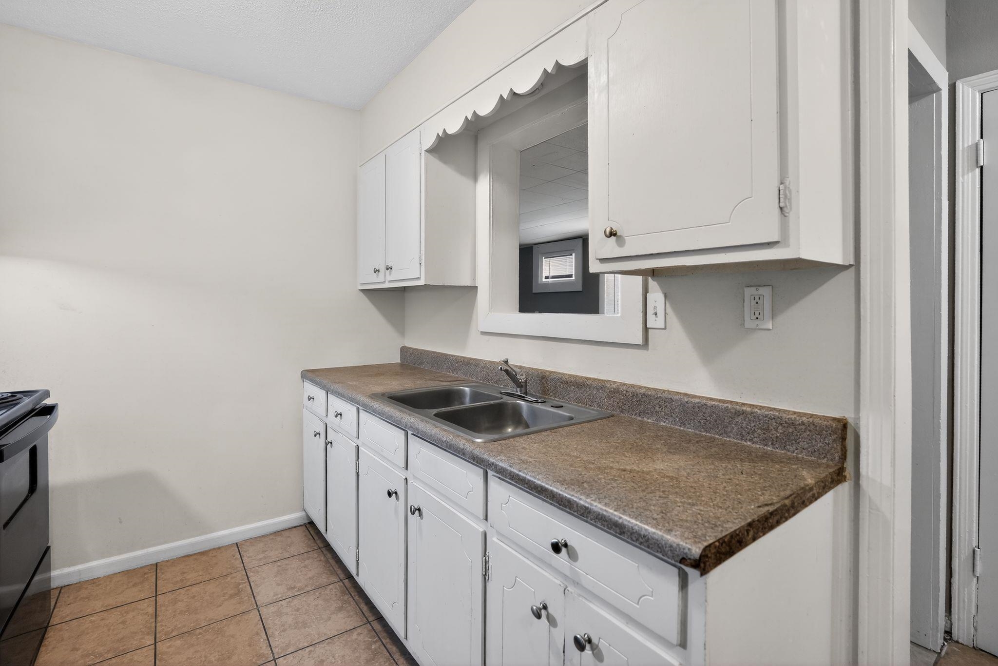 3741 Ridgemont Road Memphis, TN 38128 - Photo 20 of 32 Kitchen with white cabinets, dark countertops, light tile patterned flooring, and black electric range