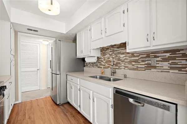 a kitchen with stainless steel appliances granite countertop a sink a stove and a refrigerator