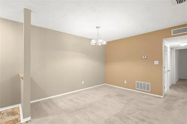 a view of an empty room with a fireplace and a window