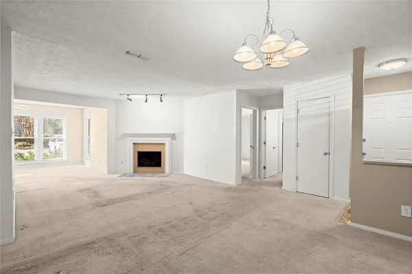 an empty room with windows and fireplace