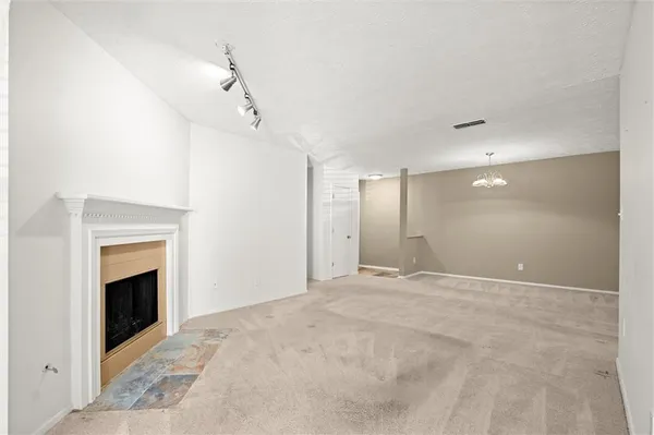 a view of an empty room with a fireplace and a window