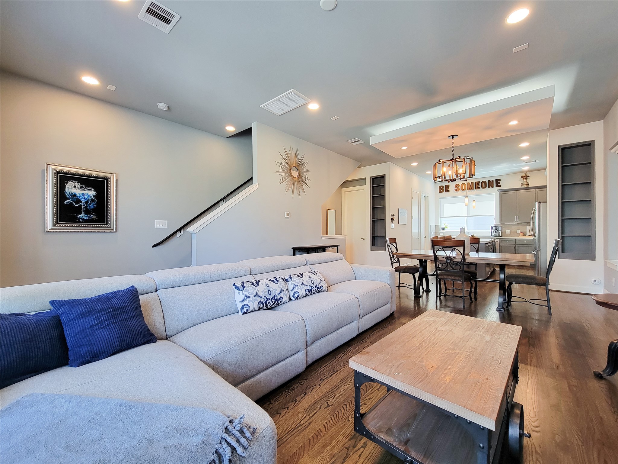 1705 Eado Point Lane Houston, TX 77003 - Photo 20 of 50 An open-concept living and dining area with modern decor. The room is well-lit with recessed lighting and has hardwood floors throughout, creating a warm and inviting atmosphere.