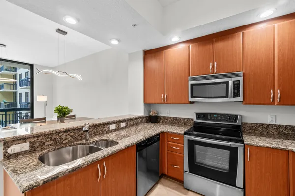 a kitchen with granite countertop stainless steel appliances and wooden cabinets