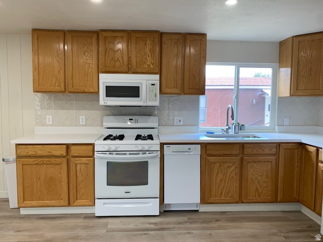 1500 North Angel Street West, Unit 56 Layton, UT 84041 - Photo 10 of 20 Kitchen featuring light wood-finish cabinetry, white countertops, white tile backsplash, a stainless steel sink with a gooseneck faucet, dishwasher and wood-finish flooring